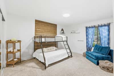 Inviting secondary bedroom offers a spacious layout, large window, plush carpeting, custom accent wall, and flexible use for guests, family, or additional sleeping accommodations.