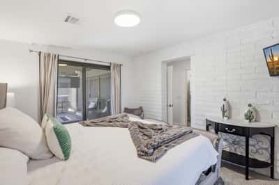 Guest bedroom enjoys direct patio and pool access through expansive sliding doors, blending indoor comfort with Scottsdale's desirable outdoor lifestyle.