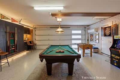 Virtually staged garage demonstrates the potential for a stylish entertainment room with gaming, billiards, and gathering space while maintaining premium built-in storage in this Scottsdale home.