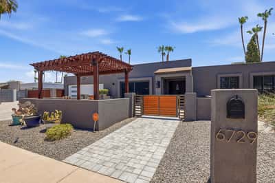 Elegant gated entrance and pergola-covered patio create a warm welcome to this renovated Scottsdale home. Modern finishes, privacy, and striking curb appeal set the tone from the moment you arrive.