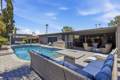 Private backyard retreat features a sparkling pool, spa, outdoor bar, and expansive paver patio with multiple seating areas. Enjoy resort-style living designed for year-round Scottsdale entertaining.