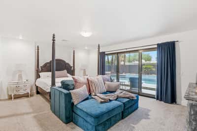 Relax in the spacious primary bedroom featuring pool views, generous natural light, and direct backyard access. A peaceful retreat designed for comfort and everyday luxury.