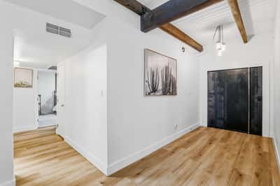 Dramatic entry welcomes guests with vaulted ceilings, exposed wood beams, luxury flooring, and clean architectural lines that define this beautifully renovated Scottsdale home.