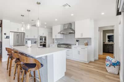 Large quartz island with breakfast bar seating creates the perfect place for casual dining and conversation. The open layout blends beautifully with the surrounding living spaces.
