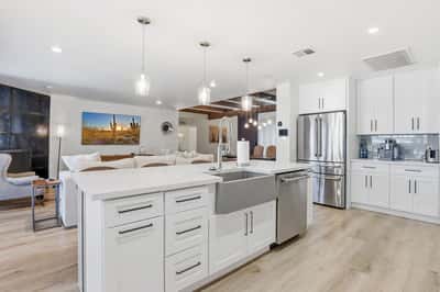 Spacious kitchen features a farmhouse sink, oversized island, custom cabinetry, and an open design overlooking the living room, making entertaining effortless year-round.