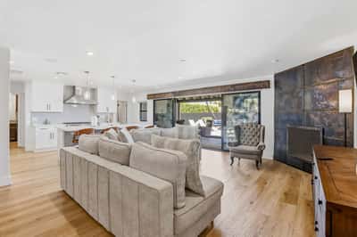 Spacious living area flows effortlessly into the gourmet kitchen and backyard patio, showcasing updated finishes, luxury flooring, fireplace, and abundant natural light throughout.