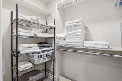 Spacious walk-in storage closet features built-in shelving and hanging space for linens, seasonal items, and everyday organization, adding valuable storage to this Scottsdale home.