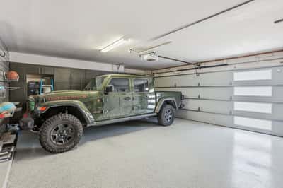 Finished garage includes durable epoxy flooring, modern garage door, extensive storage cabinetry, and room for larger vehicles or recreational equipment in this Scottsdale residence.