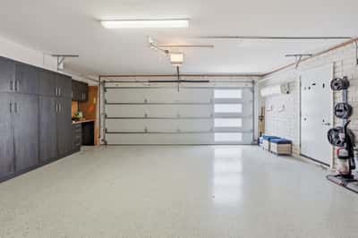 Spacious garage features a mini-split HVAC system, built-in storage cabinets, epoxy flooring, and flexible workspace for hobbies, projects, or climate-controlled storage in Scottsdale.