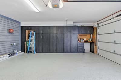 Custom garage organization includes full-height cabinets, integrated workbench, slat wall storage, and durable epoxy flooring, creating an efficient and well-appointed workspace in Scottsdale.