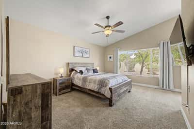 Enjoy a spacious owner's suite featuring vaulted ceilings, plush carpet, oversized windows, and peaceful backyard views. This comfortable bedroom offers the perfect place to relax at the end of the day.