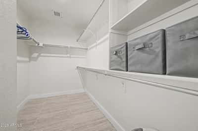 This spacious walk-in closet provides extensive shelving, hanging rods, and organized storage solutions for clothing, shoes, and seasonal items while complementing the home's functional layout.