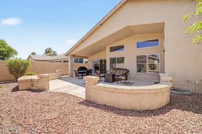 Enjoy a thoughtfully landscaped backyard with mature shrubs, decorative rock, privacy walls, and spacious patio areas designed for easy maintenance and year-round outdoor enjoyment.