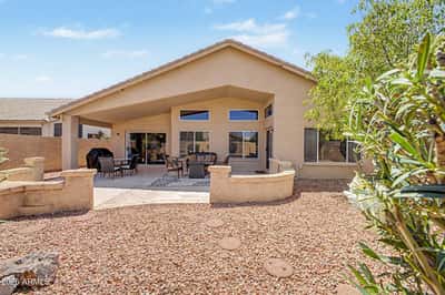 The backyard offers an expansive covered patio, mature landscaping, and easy-care desert landscaping designed for year-round enjoyment. Large windows and sliding glass doors create seamless indoor-outdoor living, making this Goodyear rental ideal for entertaining and everyday relaxation.