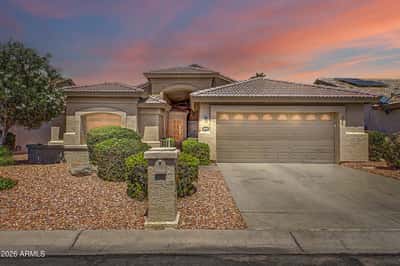 Presented in a striking twilight setting, the front exterior highlights the home's welcoming entrance, attractive desert landscaping, spacious driveway, and attached two-car garage. This professionally maintained Goodyear rental offers outstanding curb appeal in a desirable neighborhood that is not a 55+ community and is not located on a corner lot.