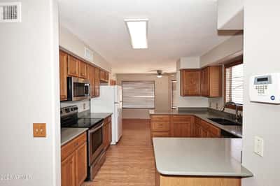 Functional kitchen features extensive cabinetry, breakfast bar seating, ample countertop space, and an open layout connecting effortlessly to the living areas.