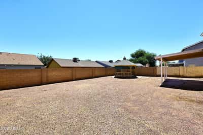 Large backyard provides abundant outdoor living space with privacy walls, easy-care landscaping, and endless possibilities for recreation.