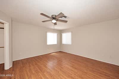 Inviting primary bedroom offers generous living space, updated flooring, multiple windows, and a relaxing atmosphere ideal for everyday comfort.