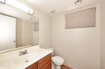 Convenient half bathroom includes a vanity with storage, oversized mirror, and easy access for guests and everyday household use.