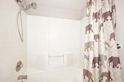 Full hall bathroom offers a tub and shower combination with built-in storage niches, providing convenience for everyday living.
