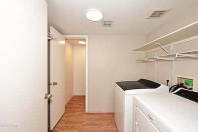 Functional laundry room includes washer and dryer, built-in shelving, and convenient storage to simplify everyday household tasks.