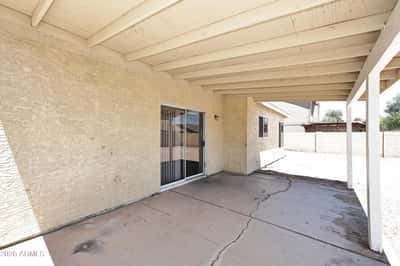 Covered patio provides comfortable outdoor living space with direct backyard access, making it perfect for relaxing or entertaining in Phoenix.