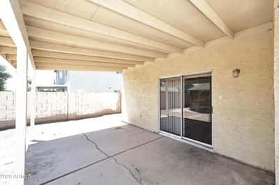 Expansive covered patio extends the living space outdoors with a comfortable shaded area overlooking the backyard, perfect for relaxing or hosting family and friends.