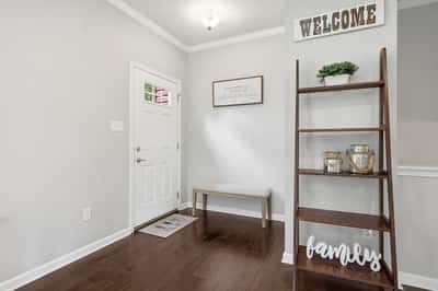 Bright entryway featuring a modern design with warm wooden accents and inviting decor.