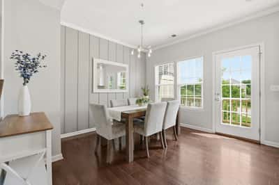 Bright dining area with modern finishes, large windows, and direct access to the outdoor space.