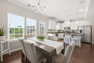 Bright and airy kitchen and dining area featuring modern appliances and abundant natural light from large windows.