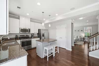 Modern kitchen with stainless steel appliances, a spacious island, and open layout connecting to the living area.