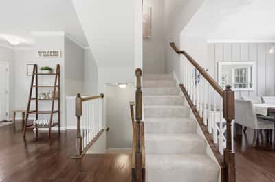 Bright and inviting foyer with staircase leading to spacious living areas and modern finishes throughout.