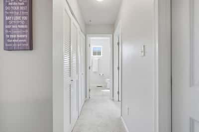 Bright and airy hallway leading to well-appointed rooms, featuring soft carpeting and convenient layout.