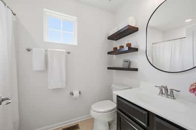 Bright and functional bathroom featuring modern fixtures, ample storage, and natural light from the window.