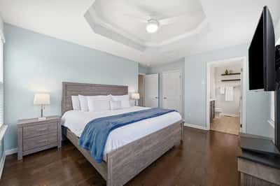Spacious bedroom featuring a coffered ceiling, modern lighting, and a convenient en-suite bathroom.