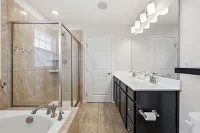 Modern bathroom featuring dual sinks, a spacious walk-in shower, and a relaxing soaking tub.