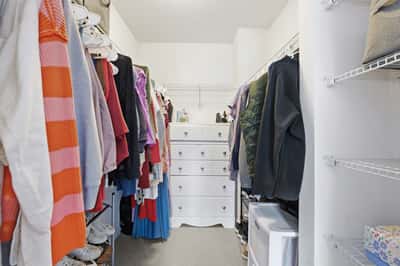 Spacious walk-in closet features ample storage with shelves and drawers, perfect for organization and easy access.