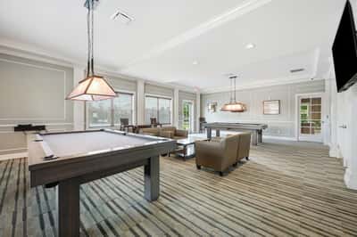 Spacious entertainment lounge featuring pool tables and ample seating, perfect for social gatherings and relaxation.