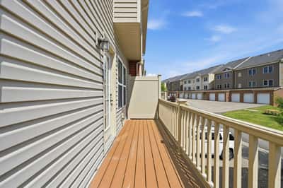 Spacious balcony with ample room for outdoor seating, overlooking a well-maintained community.