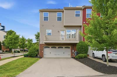 Spacious end-unit townhouse featuring a two-car garage and a private balcony overlooking landscaped grounds.