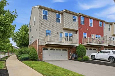 Spacious end-unit home featuring a large balcony, landscaped yard, and convenient garage parking.