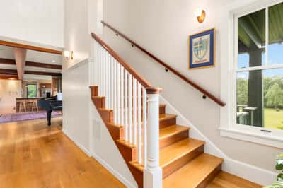 Bright and inviting entryway with handcrafted wood finishes, leading to spacious living areas and scenic views.
