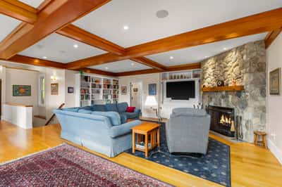 Spacious living area featuring a cozy fireplace, built-in shelves, and ample natural light throughout.