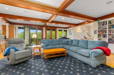 Spacious living area featuring a cozy sectional sofa, natural light, and easy access to outdoor views.