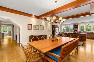 Spacious dining area features expansive windows, warmly lit wood accents, and an inviting atmosphere for gatherings.