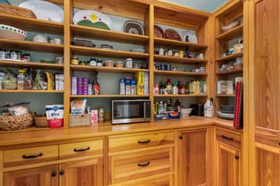 Spacious pantry featuring built-in shelving and ample storage for organized food and kitchen essentials.