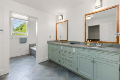 1 of 2 second floor bathrooms featuring dual sinks, ample counter space, and natural light from large windows.