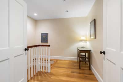 Bright and inviting landing featuring warm wood floors, a functional workspace, and soft ambient lighting.