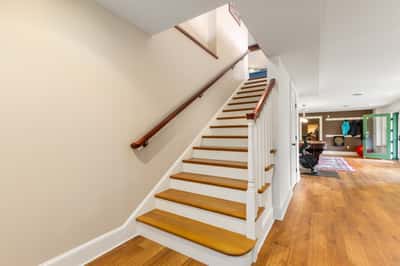 Bright and welcoming staircase leads to versatile living spaces perfect for relaxation or entertainment.