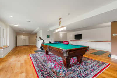 Spacious recreational room featuring a pool table, exercise equipment, and ample storage for entertainment needs.